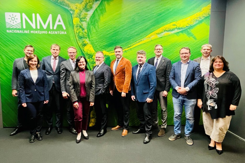 Photo of 12 people smiling in front of a NPA logo wall